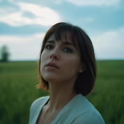 woman in a field gazing at the sky