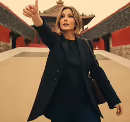 a woman wearing a business suit pointing at something