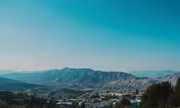 the blue sky looks great with mountains and houses