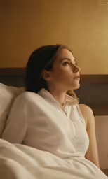 a woman sitting down while staring away from the camera