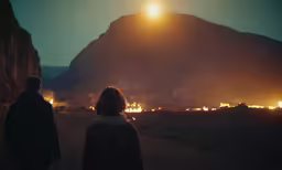 a couple standing in the sun in a dark place