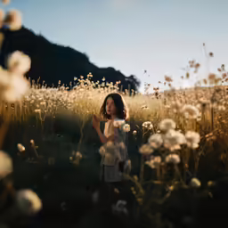 a woman standing in a field looking off into the distance