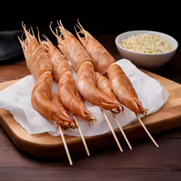 several shrimp skewers are placed on a wooden tray