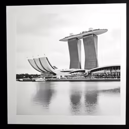 some tall buildings sitting next to water in a black and white photo