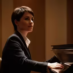 a young woman is playing the piano while in an office setting