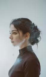 woman in brown coat and silver necklace looking away