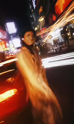 woman walking down the street at night in the city