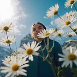 a woman standing between flowers looking up in the sky