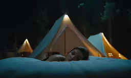 a person laying in bed looking at the camera