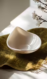 a white dish and flower on a green mat