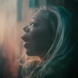 a close up of a person wearing glasses in the dark