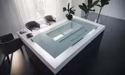 a table with a vase on top of it and a plant near by