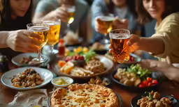 many people sitting at a table with food and drinks