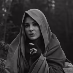 a black and white photo of a young woman dressed in her towel