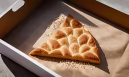 a slice of pastry with seeds on top of it in a pizza box
