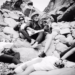 people sit together on rocks and rock formations