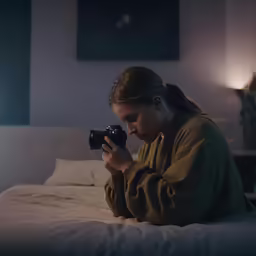young woman taking a photo in her bedroom
