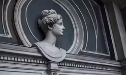 a bust sitting on the side of a building next to a door