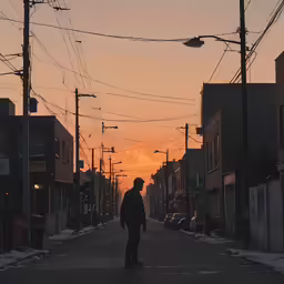 the person walks down the street on a skateboard at sunset