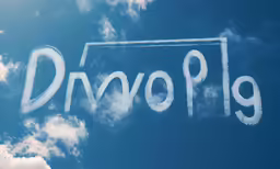 a plane flying across the sky in the blue sky