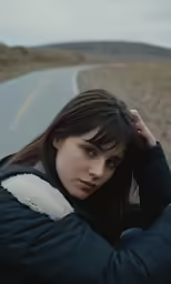 the woman is leaning against the rail on the road