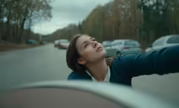 a young girl is sitting behind the dashboard