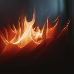 a red piece of cloth on fire on dark background