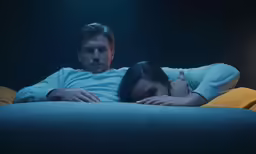 a man and a woman laying down with their arms on each other