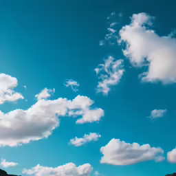 a big clear blue sky above some green mountains
