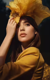 the woman is wearing a yellow top and a large flower in her hair