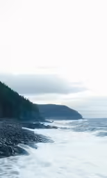 a view of some cliffs in the water from the shore
