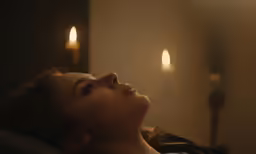 a woman is laying on her stomach by a wall light