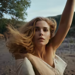 the young lady is holding her hair high up