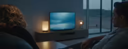 two people sitting in front of the television