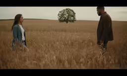 two people standing in the middle of a field