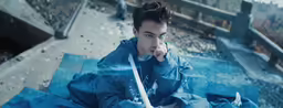 a young man wearing blue jacket talking on a cell phone