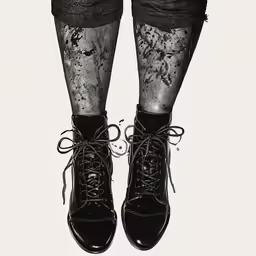 two women in black boots standing together