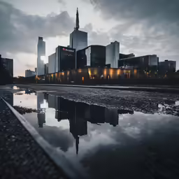 a reflection in water near large buildings in the city