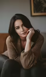 a woman wearing black leggings sitting on a brown couch