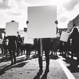 black and white image of a protest march carrying a sign