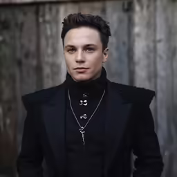 a person posing for a photo in a black jacket