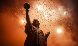 the statue of liberty has fireworks in the sky behind him