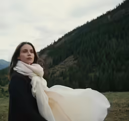 the young woman is carrying a white scarf