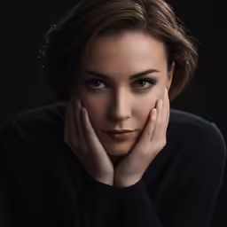 a close - up photo of a woman posing with her hands over her face