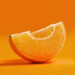 a half eaten slice of orange with droplets on it