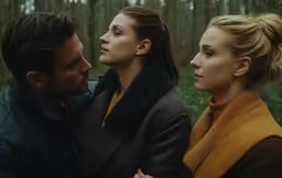 the couple are standing together outside in a forest