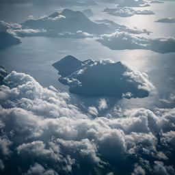 the sky is full of clouds as the ocean looks over land