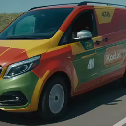 a red and yellow van driving down the street