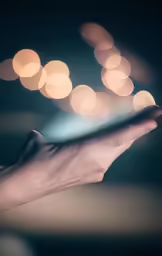 an outstretched hand holds a piece of glass