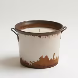a candle in a pot with some paint on it